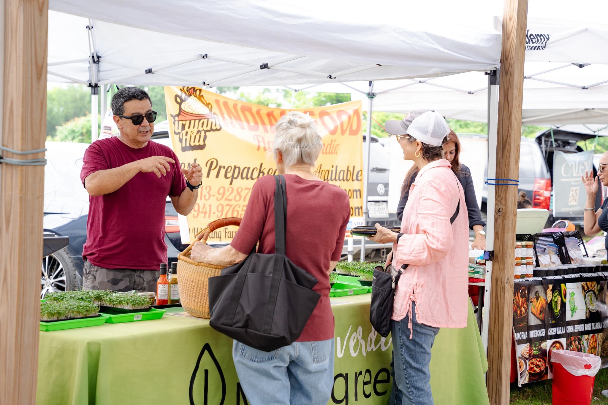 Vida Verde market booth with customers sampling products