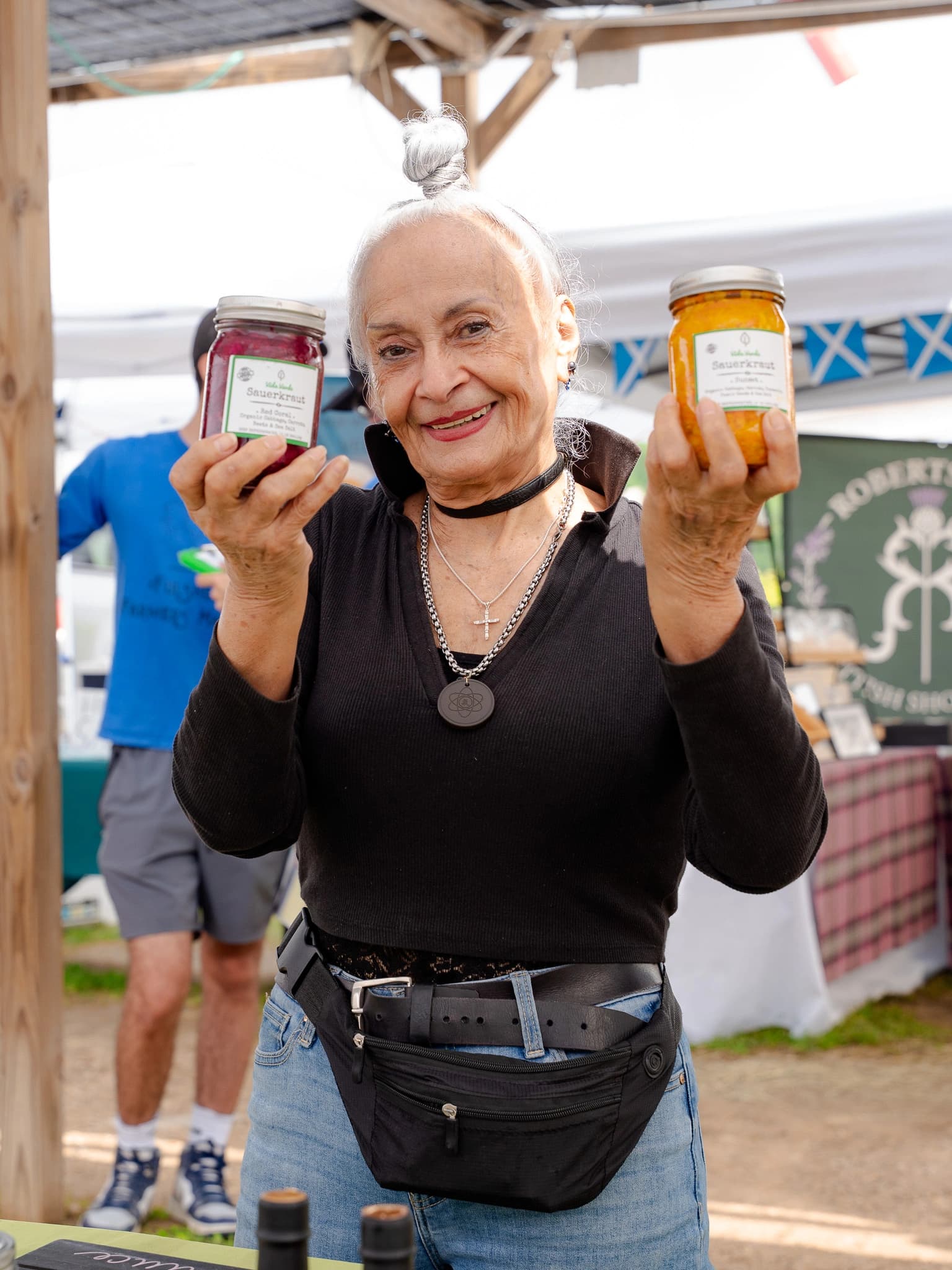 Vida Verde customer smiling while holding two jars of sauerkraut